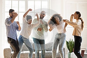 Euphoric young mixed race best friends enjoying party at home.
