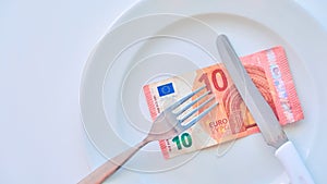 Euro banknote on a white plate, cash in Europe, the cost of lunch in the restaurant