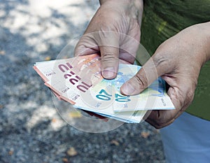 Euro banknotes close-up in the hands of an adult woman. Poverty and wealth