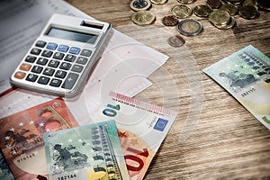 Euro banknotes and coins with bills to pay. Finances and budget