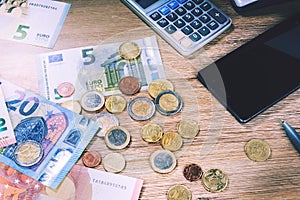 Euro banknotes and coins with bills to pay. Finances and budget