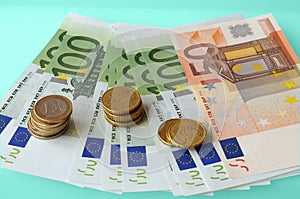 Euro banknotes and coins on light background