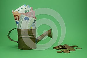 Euro banknotes in a copper watering can