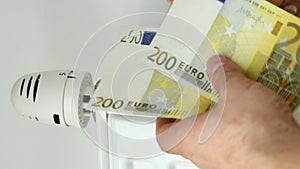 Euro banknotes are counted and put on the radiator, rising prices of heating apartments before winter, Energy costs for domestic h