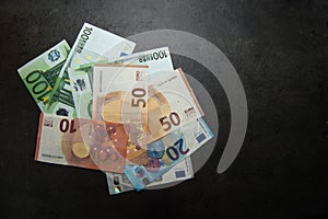 Euro banknotes on a dark background whit copy space view from top