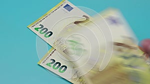 Euro banknotes fall on the blue table.