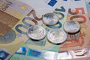 Euro banknotes from fifty to two hundred and Euro coins. European monetary union currency. Economic and fiscal stimulus