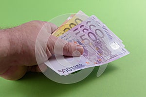 Euro banknotes in hand. close-up. Green background
