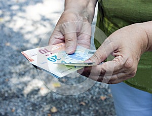 Euro banknotes in the hands. Adult woman counts money