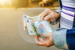 Euro banknotes in hands of elderly woman. Pension payments in Europe, retirement savings or benefits concept, female pensioner