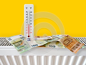 Euro banknotes on home heating radiator with thermometer. Energy crisis and expensive heating costs for winter season