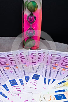EURO banknotes, hourglass on 500 notes background. Concept - time to travel