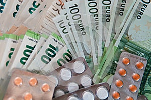 Euro banknotes and pills, concept of treatment costs, paid medicine, tranche of the International Monetary Fund for health care