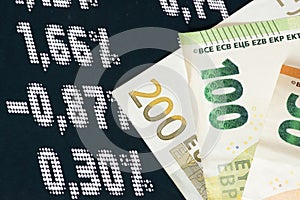 Euro banknotes and price board on the stock exchange