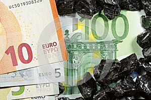 Euro banknotes on raw coal nuggets, bills on coal, power of money and ore