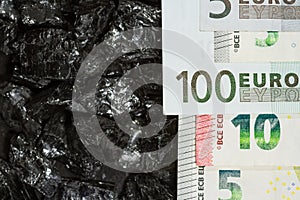 Euro banknotes on raw coal nuggets, bills on coal, power of money and ore