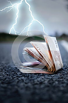 Euro banknotes on the road against thunderstorm and lightning background as symbol of global economic crisis in Europe. Vertical