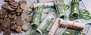 Euro banknotes rolled and euro coins in different positions