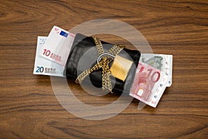 Euro banknotes secured in an locked black wallet.