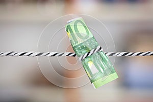 Euro banknotes tied by a rope