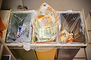 Euro banknotes in a trash can