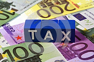 Euro banknotes with the word tax spelled out on top of the banknotes