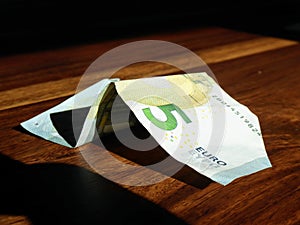 5 euro bill on wooden table, wrinkled money bill.