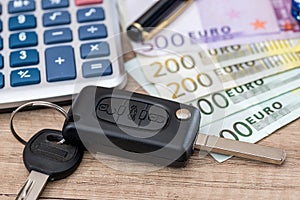 Euro bills with car key and calculator
