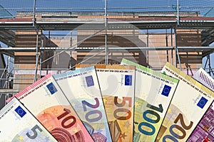 Euro bills in front of a shell construction