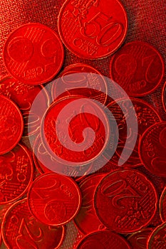 Euro cents coins close-up in red light. Euro currency inflation.Euro exchange rate in the European Union.