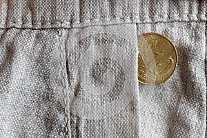 Euro coin with a denomination of 10 euro cents in the pocket of old linen pants