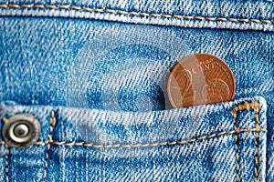 Euro coin with a denomination of 2 euro cent in the pocket of old worn blue denim jeans