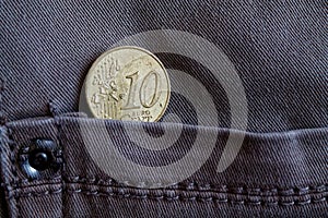 Euro coin with a denomination of 10 euro cent in the pocket of worn gray denim jeans
