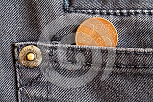 Euro coin with a denomination of two euro cent in the pocket of dark blue denim jeans