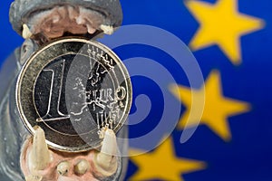 Euro coin in mouth of a hippo figurine