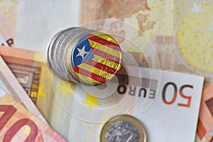 Euro coin with national flag of catalonia on the euro money banknotes background