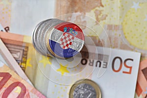 Euro coin with national flag of croatia on the euro money banknotes background.