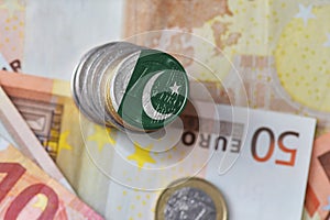 Euro coin with national flag of pakistan on the euro money banknotes background.