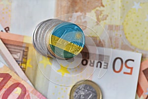 Euro coin with national flag of rwanda on the euro money banknotes background.
