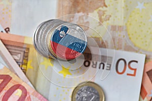 Euro coin with national flag of slovenia on the euro money banknotes background