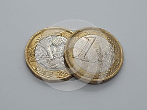 Euro coin resting on top of one pound coin