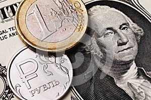 Euro coin and Russian ruble against the background of a dollar bill, close-up