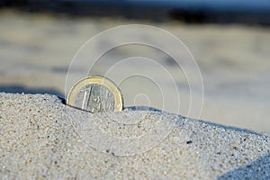 Euro coin in the sand