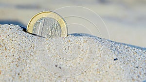 Euro coin in the sand