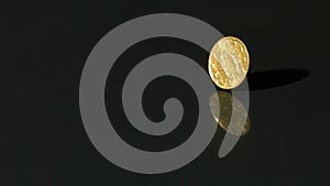 Euro coin spinning on black surface