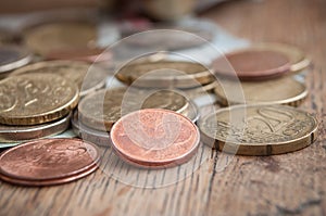 Euro coins and bank notes on wooden table background