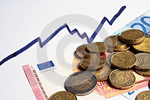 Euro coins and banknotes and rising chart line