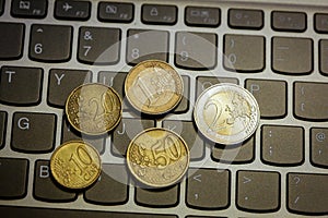 Euro coins on laptop& x27;s keyboard