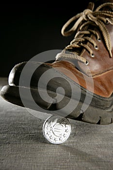 Euro currency coin tread by a boot