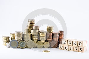 Euro currency coins building scales and wooden cubes forming the words euro coins